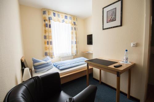 a small room with a bed and a table at Zellerfelder Hof in Clausthal-Zellerfeld