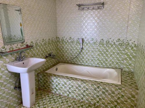 een badkamer met een bad en een wastafel bij Hotel Royal Beach & Restaurant in Jaliapāra