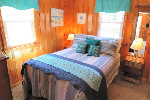 a bedroom with a bed and two windows at 2 Minute Walk to Beach, Cape Cod Escape in Dennis Port