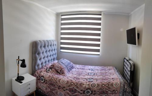 a bedroom with a bed and a window at Departamento frente a aeropuerto in La Serena
