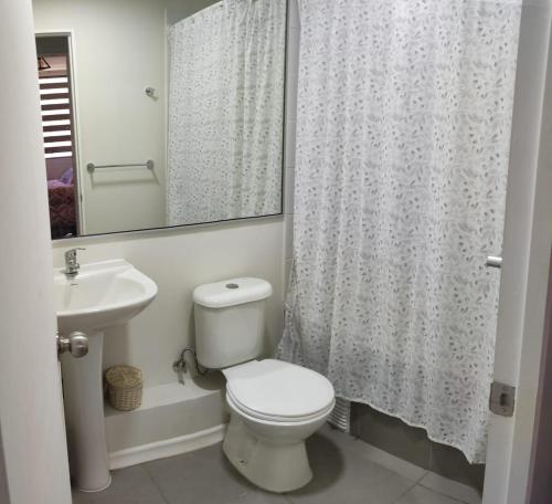 a bathroom with a toilet and a sink and a shower at Departamento frente a aeropuerto in La Serena