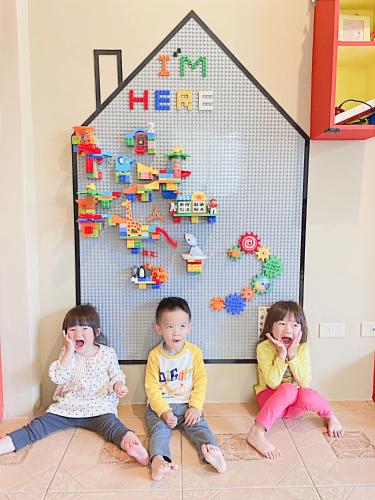 two children sitting on the floor in front of a toy house at 艾兒民宿 l 台東包棟 l 按訂房人數開放房間8-21人 in Taitung City