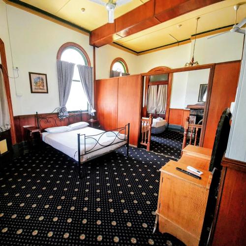 a bedroom with a bed and a mirror at Criterion Hotel-Motel Rockhampton in Rockhampton