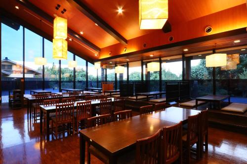 a restaurant with tables and chairs and large windows at リバティーリゾート久能山 