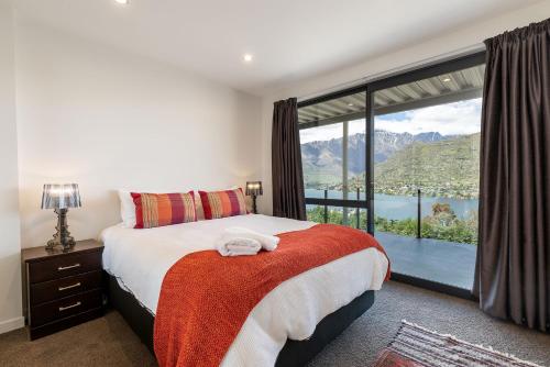 a bedroom with a bed and a large window at Okataina - Means Place of Laughter, Luxury Retreat in Queenstown