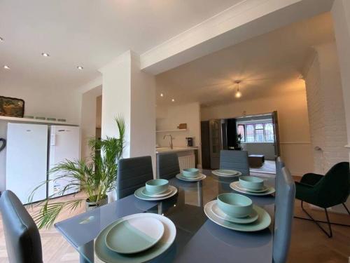 a dining room with a blue table and chairs at Lovely, recently refurbished four bedroom house.. in Hither Green