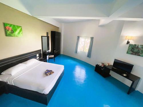 a room with a bed and a blue floor at Kuala Melaka Inn in Pantai Cenang
