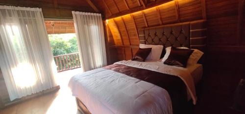 a bedroom with a bed and a large window at Belvilla 93822 Serenity Villa in Pemuteran