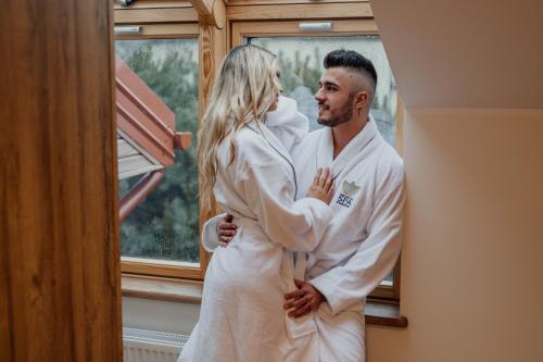 a bride and groom standing in front of a window at Medical Spa Kwiatowa in Łęczyca