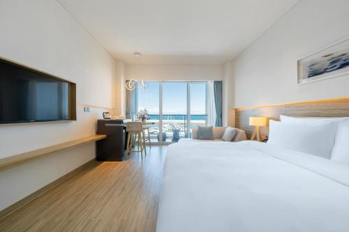 a hotel room with a bed and a flat screen tv at The Yun Resort Shenzhen Longcheer in Shenzhen
