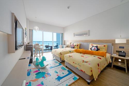 a bedroom with two beds and a desk and a kitchen at The Yun Resort Shenzhen Longcheer in Shenzhen