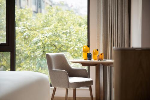 a room with a table and a chair and a window at voco Nanjing Oriental Pearl in Nanjing