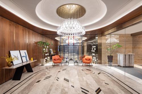 a lobby with two chairs and a chandelier at voco Nanjing Oriental Pearl in Nanjing