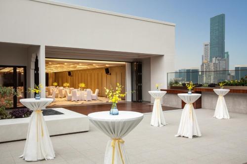 a restaurant with white tables and yellow flowers on it at voco Nanjing Oriental Pearl in Nanjing