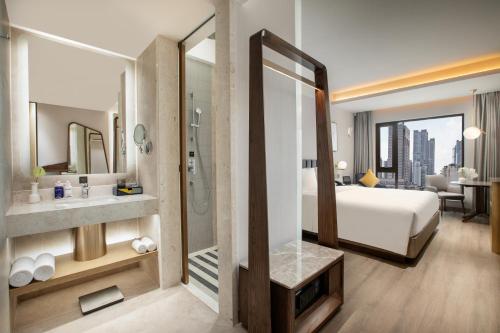 a hotel room with a bed and a bathroom at voco Nanjing Oriental Pearl in Nanjing