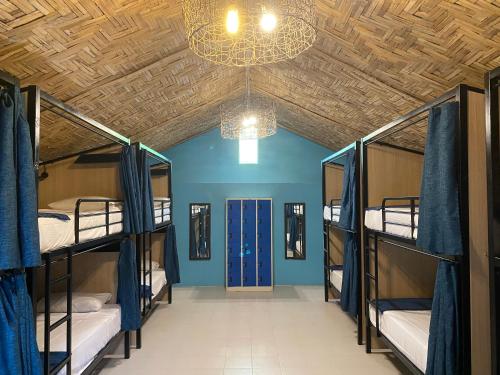 a room with four bunk beds and a chandelier at Sarana Bungalows in Baan Tai