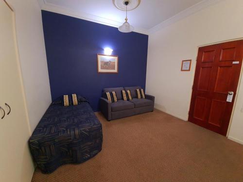 a living room with a couch and a chair at Criterion Hotel-Motel Rockhampton in Rockhampton