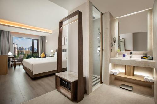 a hotel room with a bed and a bathroom at voco Nanjing Oriental Pearl in Nanjing