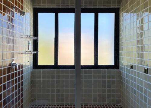 a shower with a window in a bathroom at The Empire Nimman in Chiang Mai