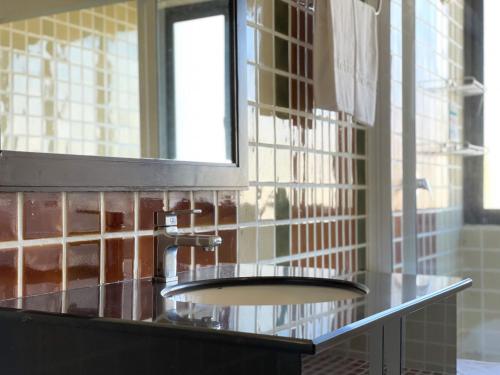 a bathroom counter with a sink and a mirror at The Empire Nimman in Chiang Mai
