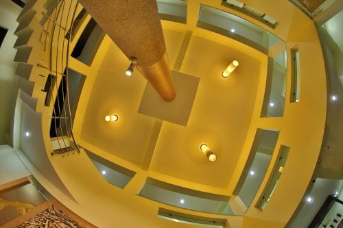 Kālapettai的住宿－HOTEL PRISO，黄色天花板的建筑中的螺旋楼梯