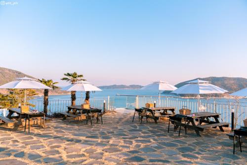 un grupo de mesas y sombrillas en una playa en Hotel SANG SANG, en Geoje