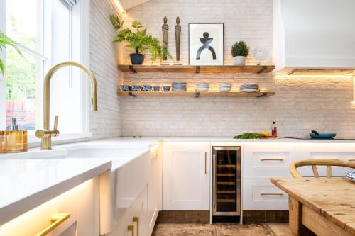 a kitchen with white cabinets and a sink at Lower Arthur's Cottage in Saddleworth, Manchester in Oldham