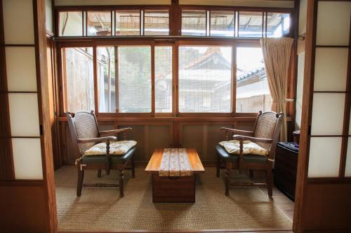 
a room with a couch, chairs and a window at Fukuzumiro in Hakone
