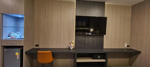 a room with a desk with a television and a chair at The Room Boutique Hotel in Sakon Nakhon