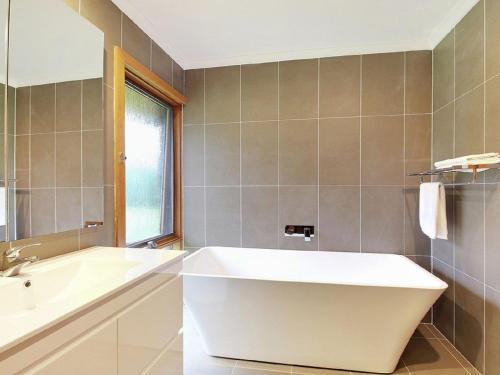 a bathroom with a large tub and a sink at Cooinda in Kangaloon
