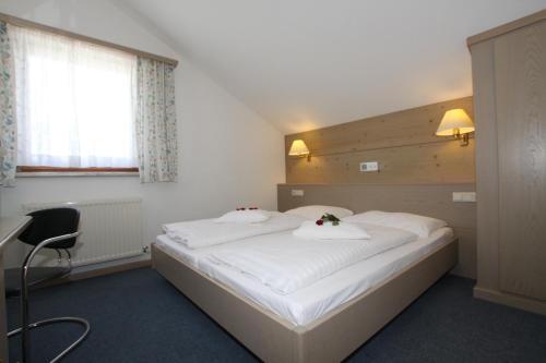 um quarto com uma grande cama branca com flores nas almofadas em Haus Aquarius em Fiss