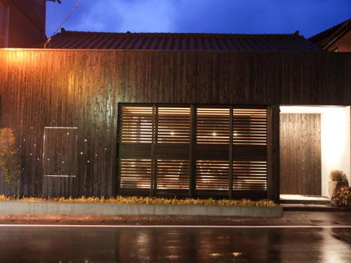 a building with a door and a fence at AsoTsuruya in Aso