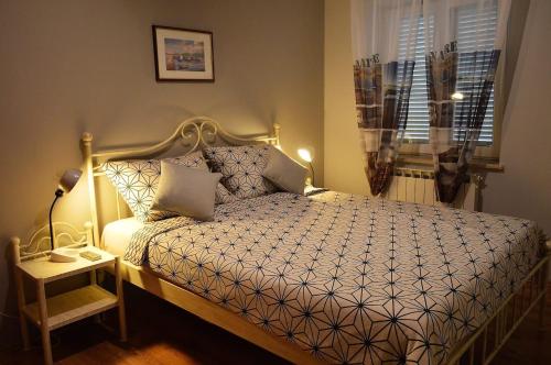 ein Schlafzimmer mit einem Bett, einer Lampe und einem Fenster in der Unterkunft Apartments Leonard - green garden in Poreč