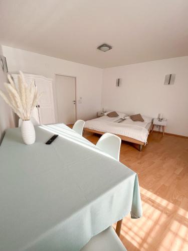 a room with two beds and a table and chairs at Pension Ingrid in Neutal