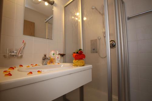 uma casa de banho com um lavatório e um chuveiro em Haus Aquarius em Fiss