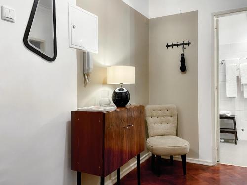 a chair and a desk with a lamp and a mirror at Claude Homes Lisbon Rato in Lisbon