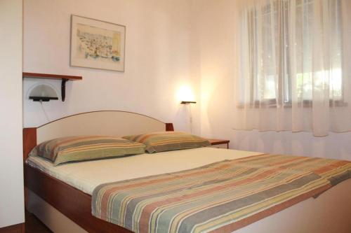 sypialnia z łóżkiem z paskiem w obiekcie Apartments Sunday in Kozino at the sea w mieście Kožino