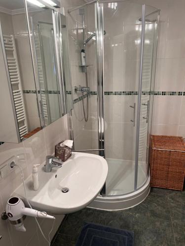 a white bathroom with a shower and a sink at Ferienwohnung Giacomelli 2 in Rottach-Egern