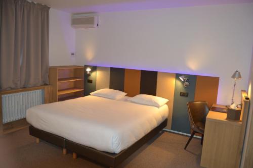 a bedroom with a large bed with a striped headboard at Cit'Hotel De Harlay in Compiègne