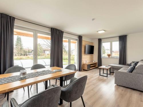 a living room with a table and chairs and a couch at Inzell Chalets with private pool in Inzell