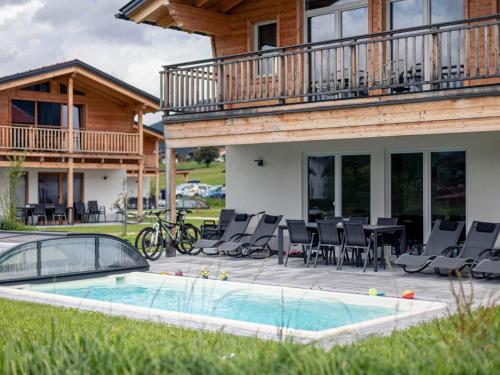 a house with a pool and chairs and a deck at Inzell Chalets with private pool in Inzell