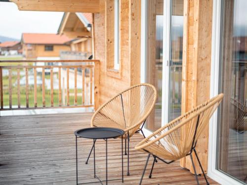 two chairs and a table on a porch at Inzell Chalets with private pool in Inzell