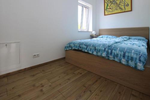a bedroom with a bed and a wooden floor at Terraced house Alex Malchow - DMS02108b-I in Malchow