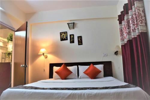 阿伯來的住宿－Premium 2 BHK Green Suites，一间卧室配有一张带红色枕头的大床