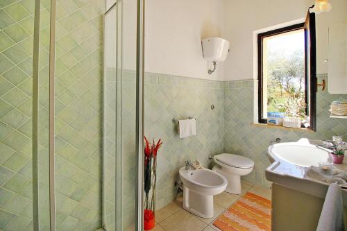 e bagno con servizi igienici, lavandino e doccia. di Apartment in Costa Rei a Costa Rei