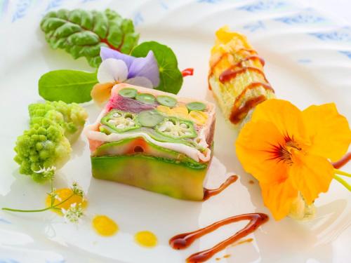 a plate of food with a piece of cake and flowers at Kunugi Relaxation with 4 modern rooms in Hakuba