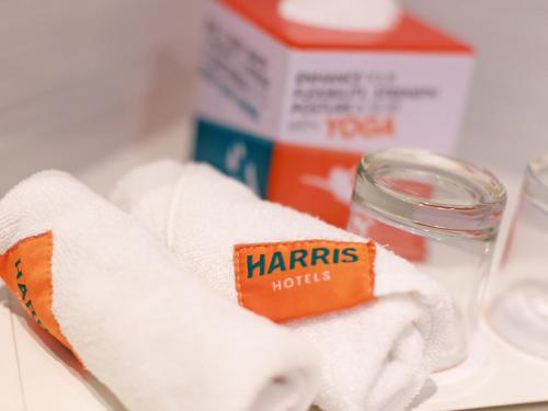 a pile of towels and a jar of honey and a container of towels at HARRIS Hotel Samarinda in Samarinda