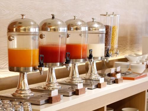 a shelf with three glass jars of different colored liquids at HARRIS Hotel Samarinda in Samarinda