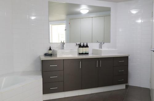 ein Badezimmer mit zwei Waschbecken und einem großen Spiegel in der Unterkunft Fiveways Balcony, King Bed, Chef's Kitchen in Fremantle