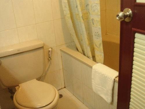 a bathroom with a white toilet and a shower at Chiangmai Ratanakosin Hotel in Chiang Mai